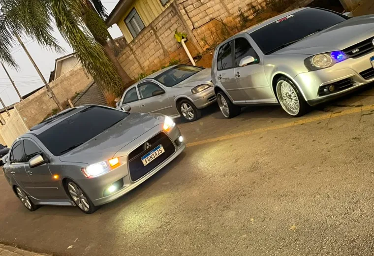 Carros prata alinhados ao entardecer após serviço